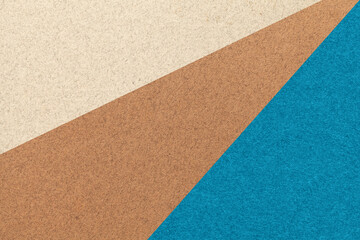 Texture of old craft beige, brown and turquoise color paper background, macro. Vintage abstract blue cardboard