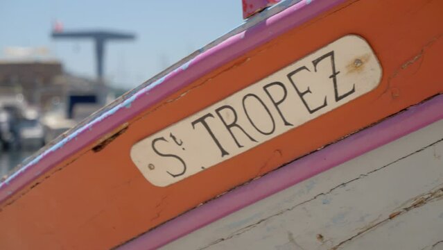 the edge of a wooden boat colored in orange with the inscription "St Tropez" a famous city of the south of France