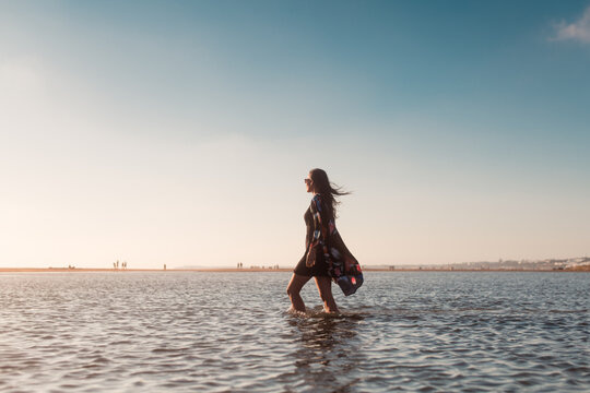 Happy woman walking in shore water