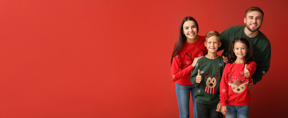 Happy family in Christmas sweaters on red background with space for text