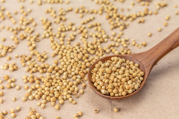 coriander seeds spoon on brown paper background.