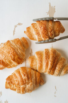 Tongs holding a croissant