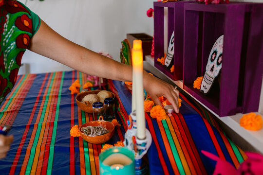 Mexican putting candles at offerings altar