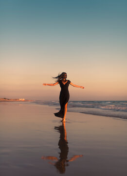 Dancing woman enjoying a moment of joy at the beach