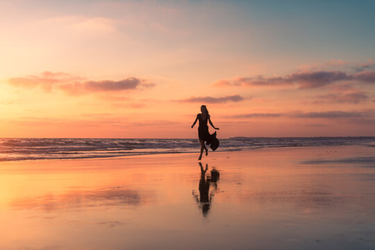 Happy woman running on daydream beach