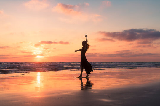 Anonymous woman enjoying dancing at the shore