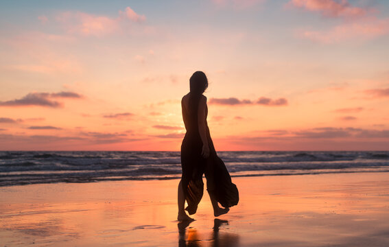Woman silhouette walking during daydream sunset