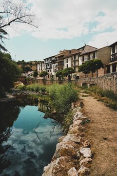 Vertical shot of the Arlanza river flowing through Covarrubias city in Burgos, Spain