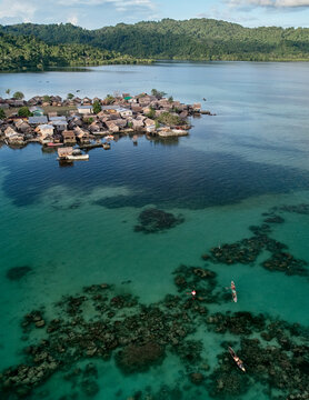 Traditional Solomon Islander native dugout canoes, stilt hut village