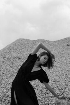 Young woman dancing in nature and wearing black dress