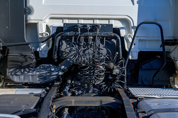 rear of a truck, of a white goods transport tractor head with all the cables and connections of black color and coiled in sight with the trailer or cockpit in sight,