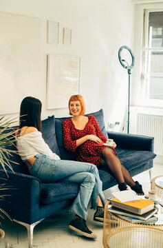 Pregnant Hairdresser Talking to Client on Sofa