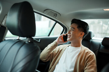 Handsome businessman using mobile phone in car. Happy face.