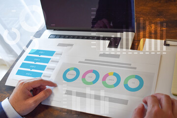 ノートパソコンと資料を確認する男性