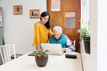 Granddaughter showing grandpa how to surf the internet at house