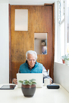 Senior reading on notebook, drinking coffee
