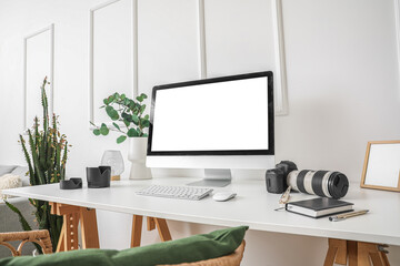 Photographer's workplace with computer and equipment in light office