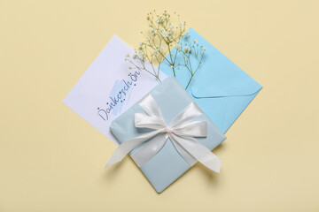 Card with text DANKE SCHON, envelope, flowers and gift box on beige background