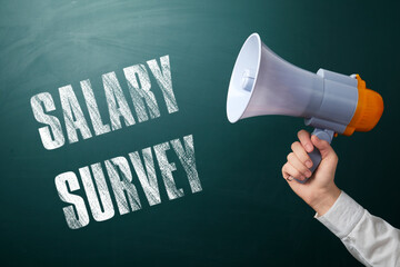 Man with megaphone and phrase Salary Survey on green chalkboard, closeup