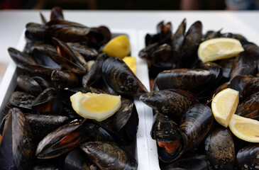Close-up cooked large mussels with lemon, ready to eat.