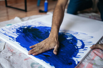 Artist painting a canvas with innovative methods