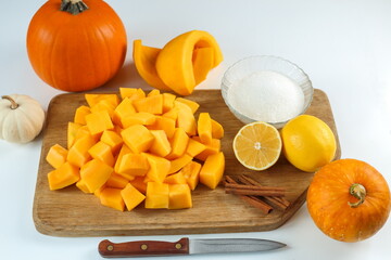 Pumpkin slices, sugar, lemons and cinnamon sticks on the board. Step 4. Step-by-step instructions. Cut the pumpkin into pieces of 1-1.5 centimeters, prepare the ingredients