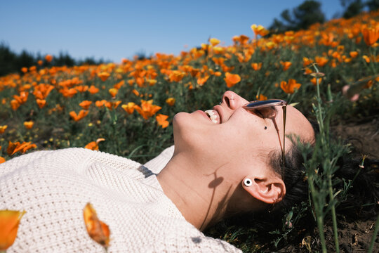 woman reclining in a field of orange flowers
