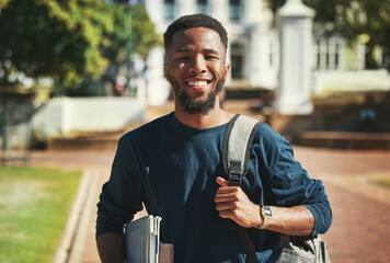 Education, campus and university portrait of student with books, backpack and ready for study, school or learning. Knowledge commitment, scholarship and studying black man happy at college building