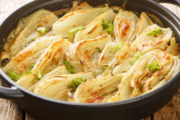 Italian food Parmesan Fennel Gratin closeup on the pan on the wooden table. Horizontal