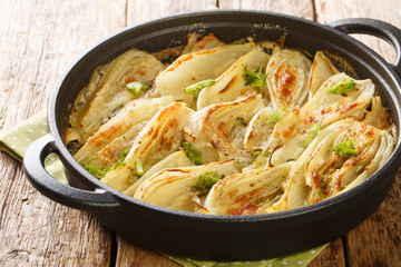 Homemade Cheesy Fennel Gratin with Parmesan closeup on the pan on the wooden table. Horizontal