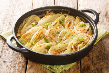 Fennel casserole with parmesan cheese and bechamel sauce close-up in a frying pan on the table....