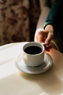 Detail shot - hand putting coffee mug on table
