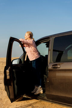 Mature woman breathing fresh air after driving