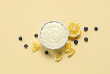 Ramekin of tasty pudding with blueberries and lemon slices on beige background