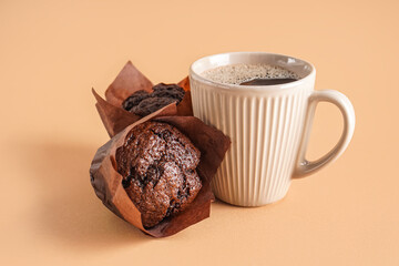 Tasty chocolate muffins and cup of coffee on color background