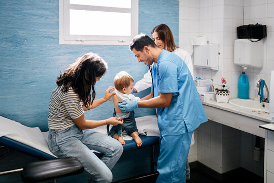 Doctor examining girl with stethoscope in hospital