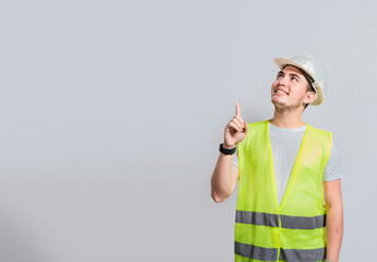 Builder engineer pointing finger to the right isolated, Portrait of engineer man pointing aside, Construction engineer with vest pointing at an advertisement, Engineer man pointing to side