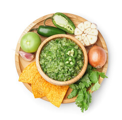 Wooden plate with bowl of green salsa sauce, ingredients and nachos on white background