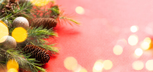 Festive composition with fir branches and golden garland light on red background. Merry Christmas and Happy new year 2023. Winter holiday celebration mockup green color