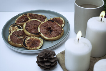 Christmas card burning candles fried oranges cones Christmas tree toys and a mug of coffee on the windowsill on a winter day