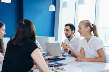 Students gather around table and talk while studying
