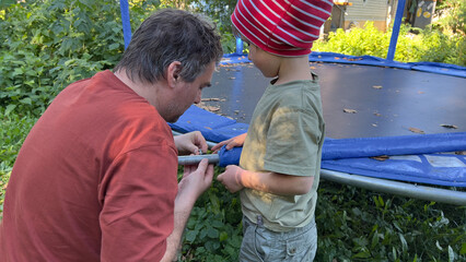 Father teaching his son to unscrew screws