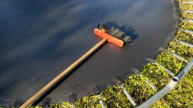 Old wooden brush laying on a trampoline