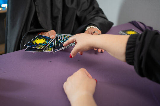 Fortune teller man reading tarot cards having a session with a client