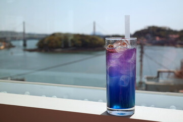 A purple drink in a glass full of ice gives a refreshing feeling