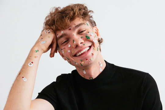 Young man with Christmas stickers smiling