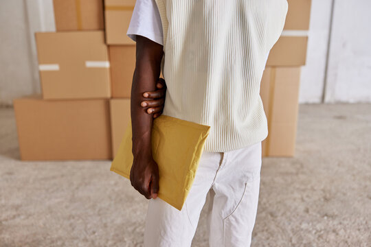 Crop black man with parcel