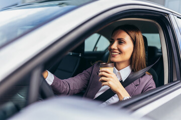 Fototapeta na wymiar Young businesswoman driving in a car to work during the day, drink coffee.
