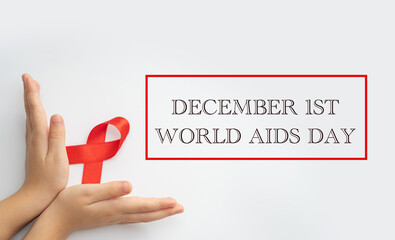World Aids Day. Child palms with red ribbon over white background. symbol of struggle against HIV, AIDS and cancer. Concept of helping those in need. Charity, donation. Mock up, blank, copy space