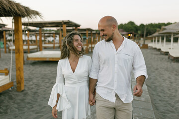 Happy young couple walking at the beach